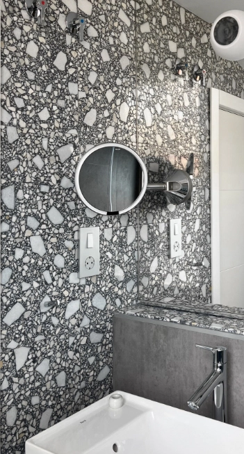 Il bagno è decorato una parete in terrazzo white e gray