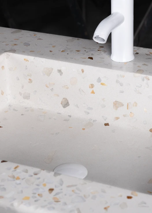 The sink is designed with white, cream, beige, gray, and brown terazzo