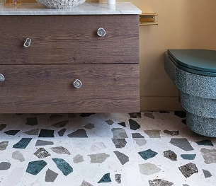 The floor of a bathroom is in white, beige, brown and green terrazzo